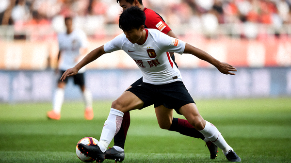 夜间足球比赛进行中，球员在灯光下争抢球权
